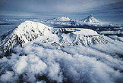 Snowcovered Tolbachik rises over clowds